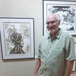 Man standing next to framed artwork